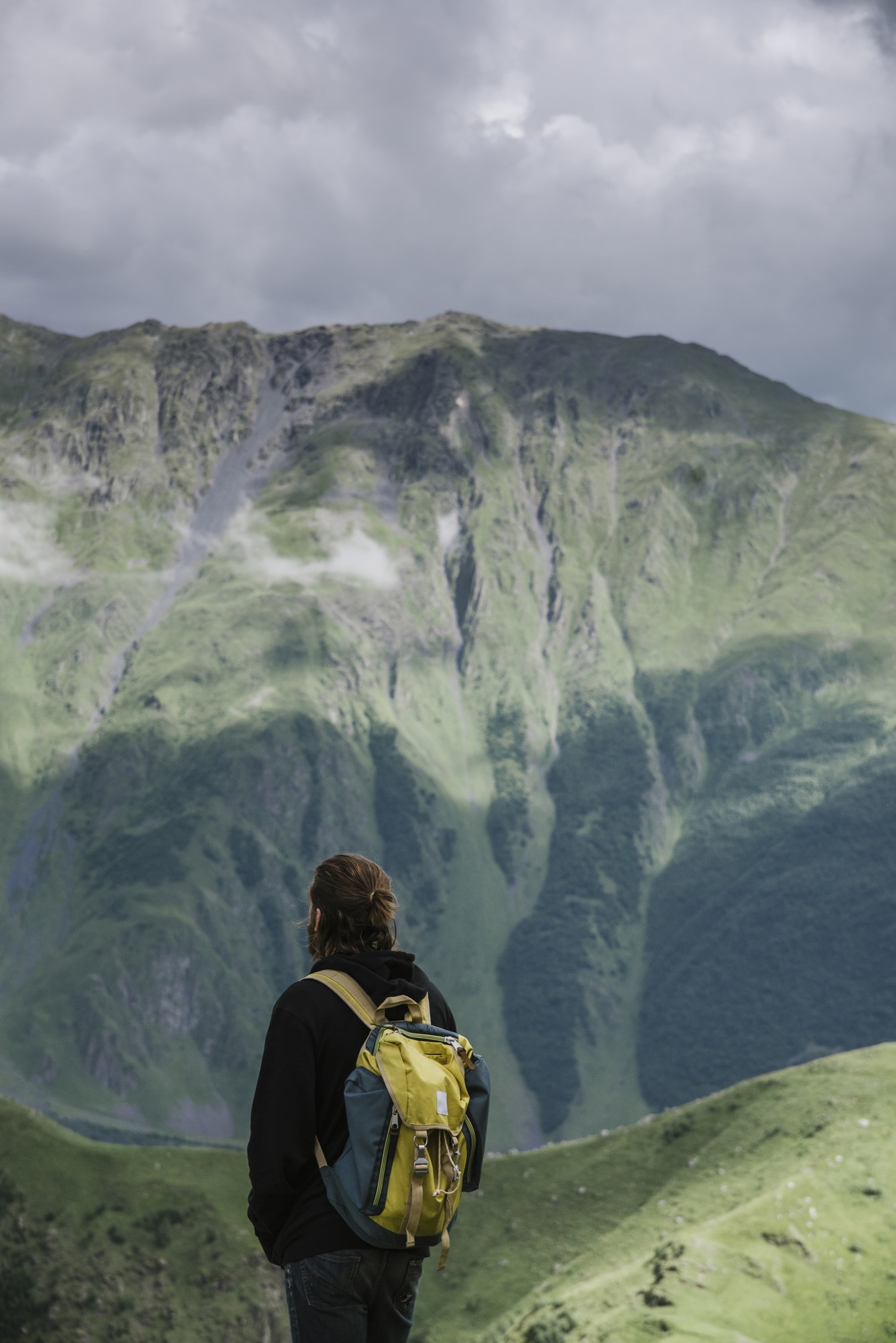Terra Aquaponie - rear-view-of-man-with-backpack-standing-in-mountain-landscape